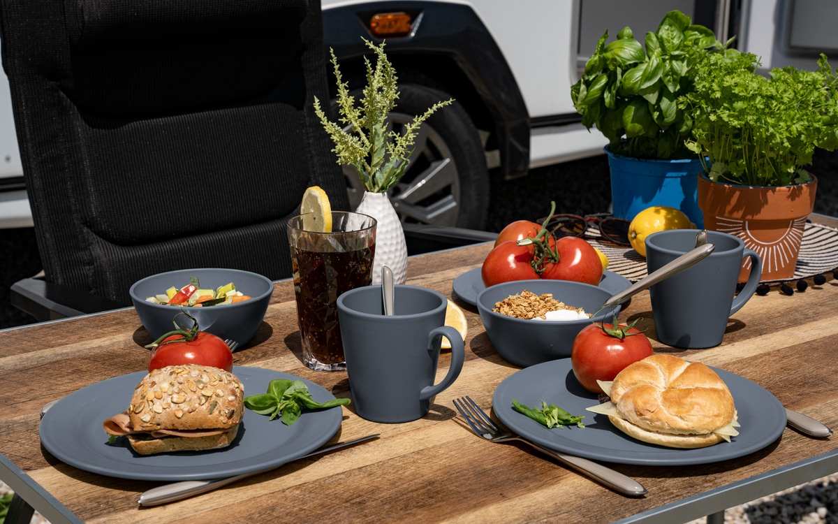 Service de vaisselle Berger Kynne bleu, dressé sur une table de camping