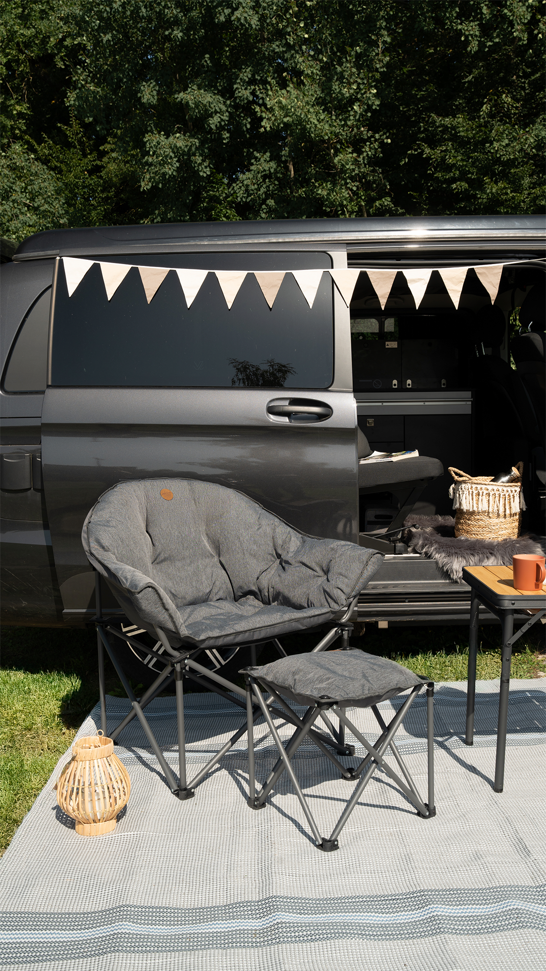 Camplife Livorno Loungesessel mit Beinauflage vor einem Camper