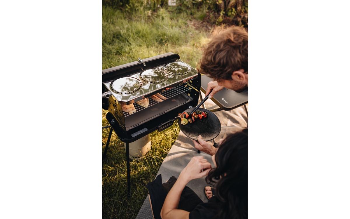 Koffergasgrill mit Grillrost und Kochfeldern im Betrieb